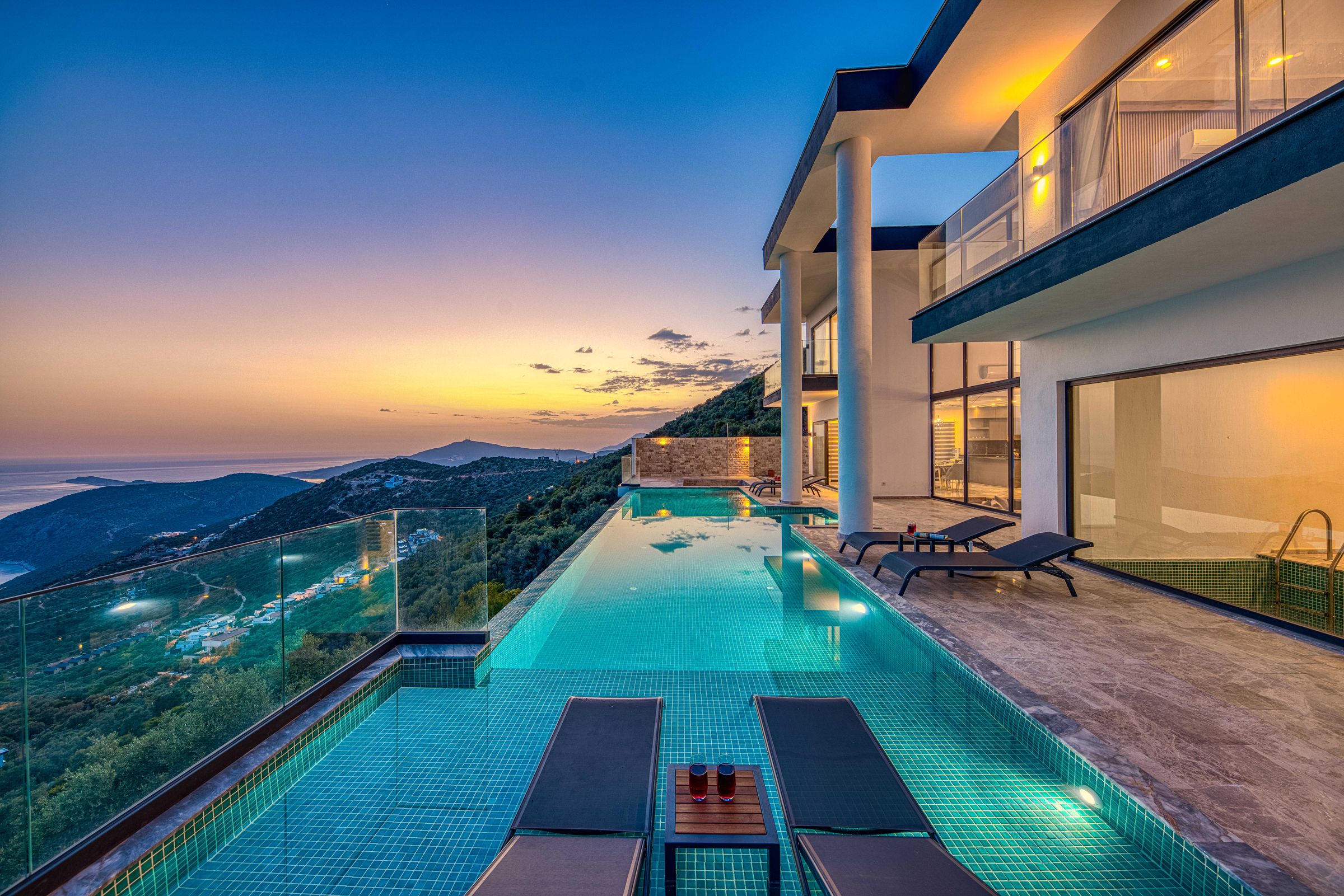 Villa contemporaine avec piscine, mer et reliefs au coucher du soleil